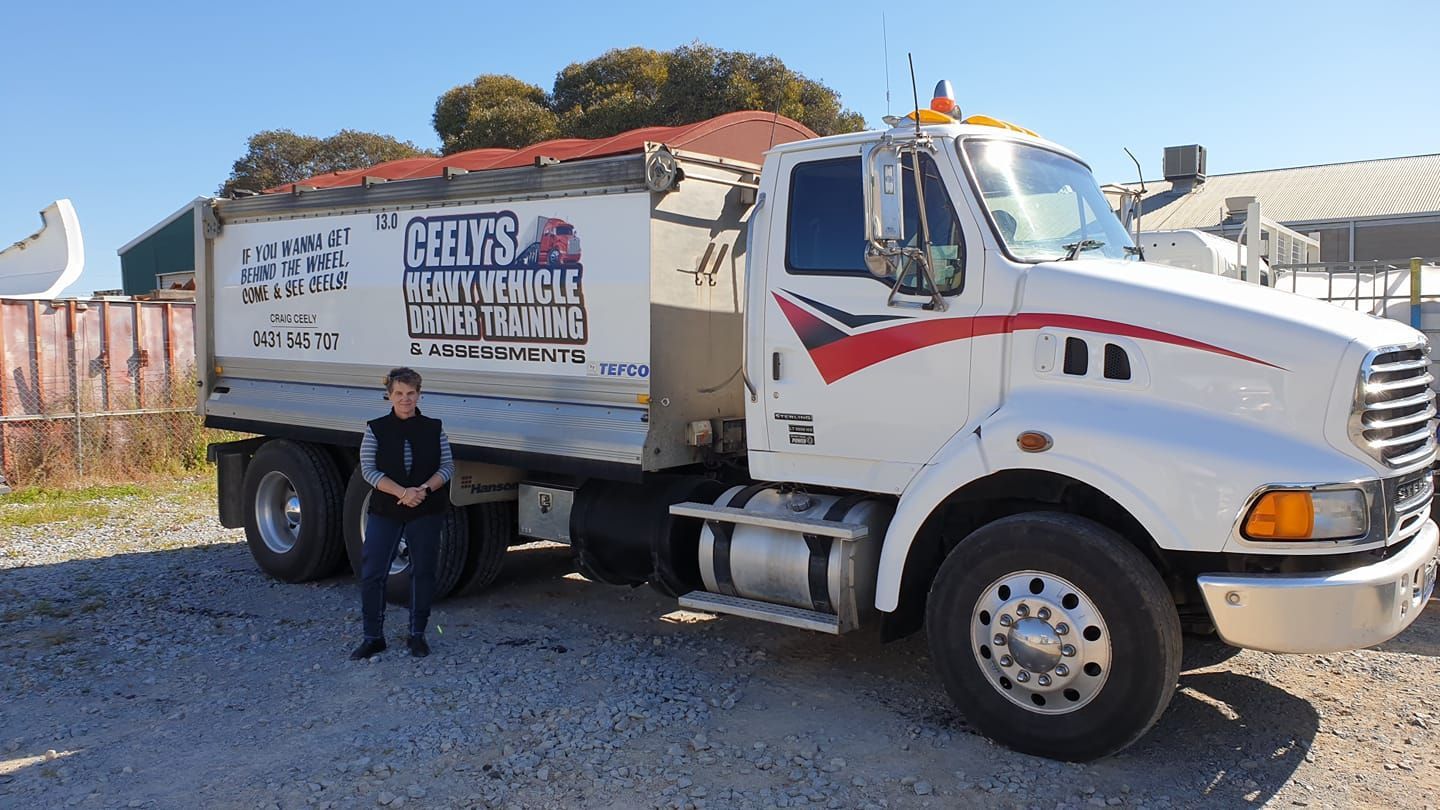 Woman With Long Sleeves Standing Beside a Truck — Ceely's Heavy Vehicle Driver Training & Assessments In Griffith, NSW