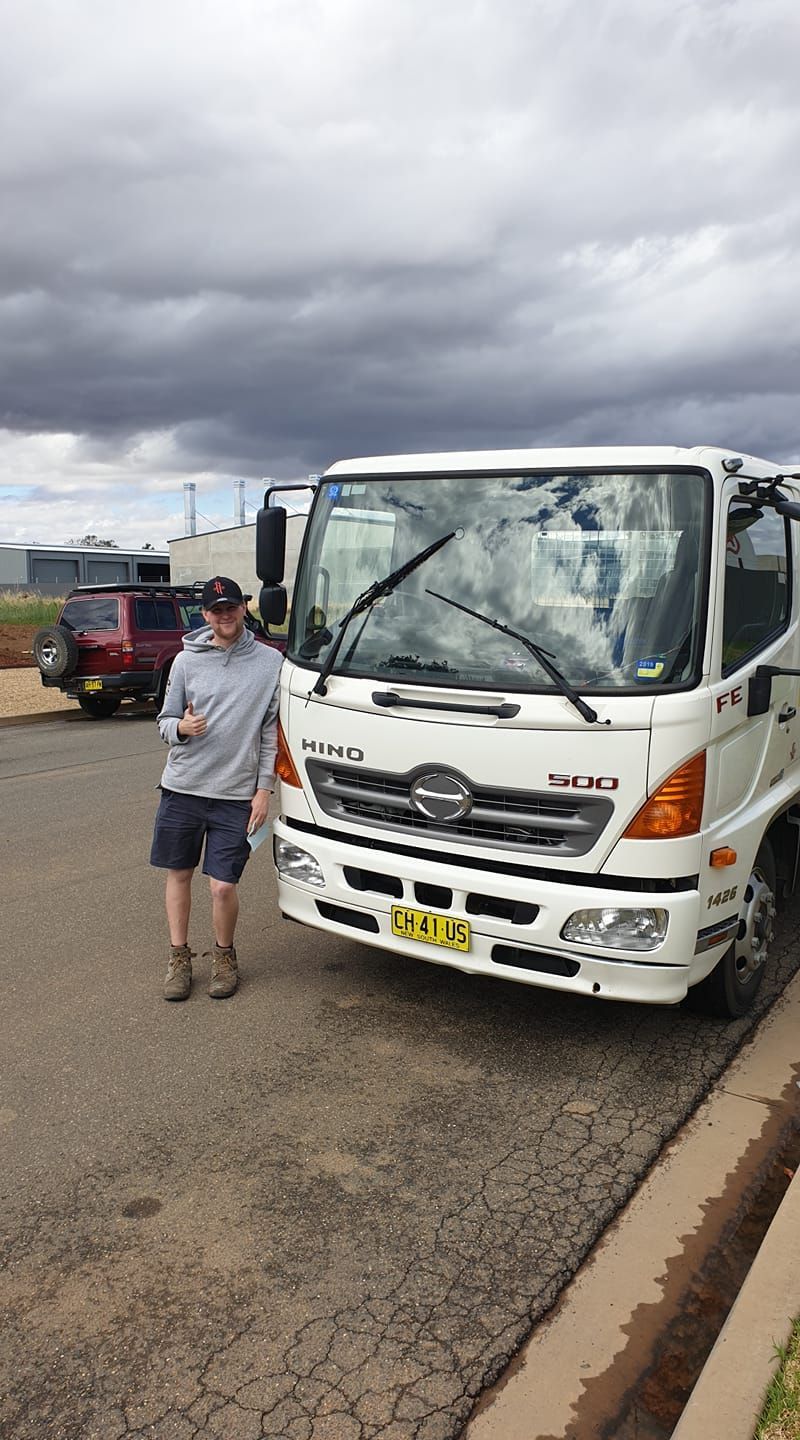 Man Wearing a Grey Hoodie Leaning on a Truck — Ceely's Heavy Vehicle Driver Training & Assessments In Griffith, NSW