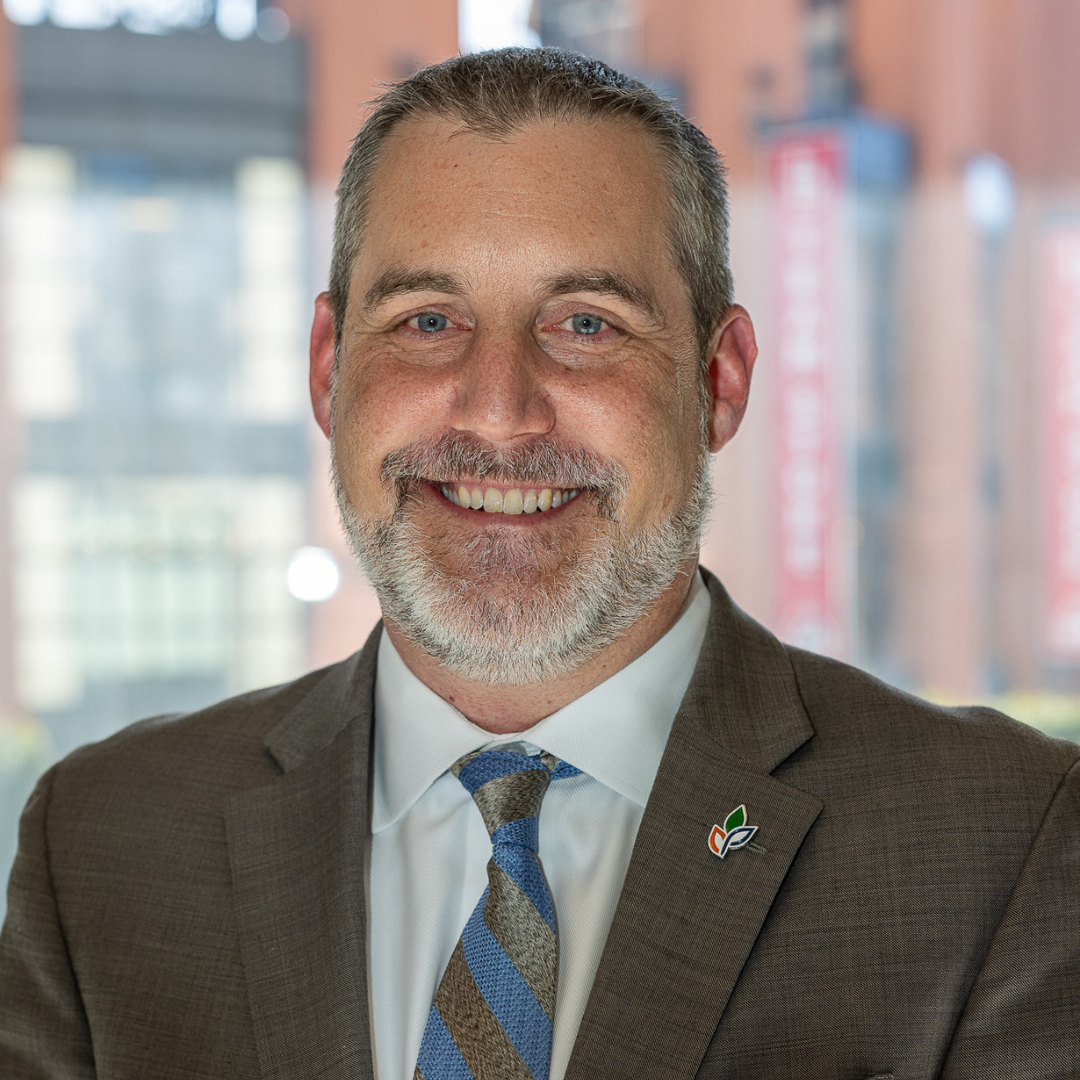 A man in a suit and tie is smiling for the camera.
