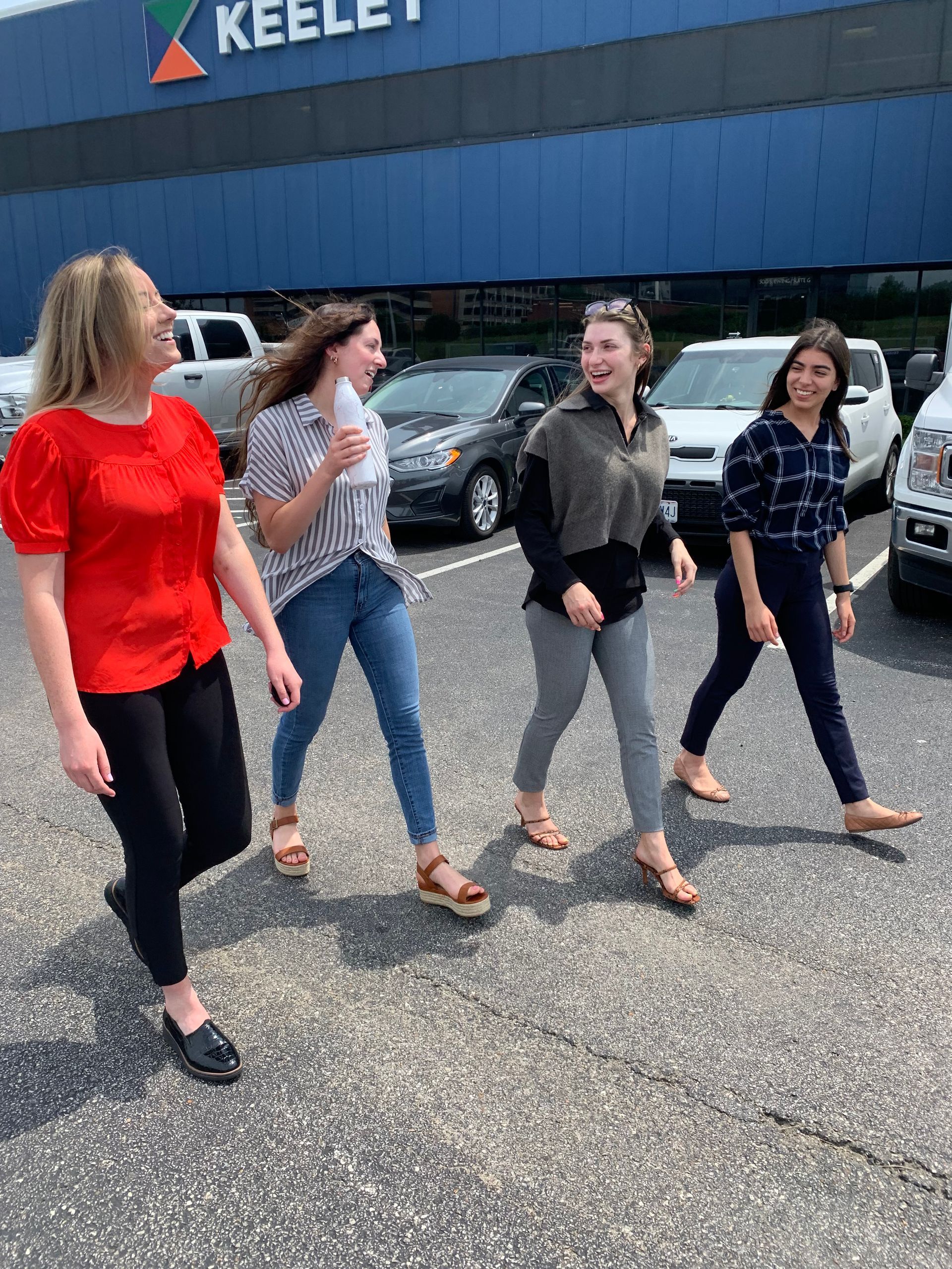 A group of women are walking down a street in front of a building.