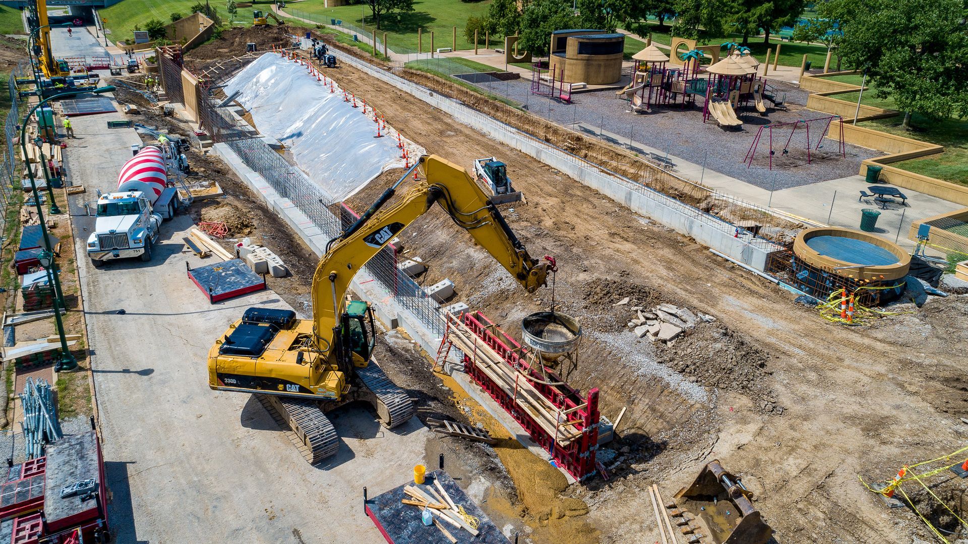An aerial view of a construction site with a yellow excavator.
