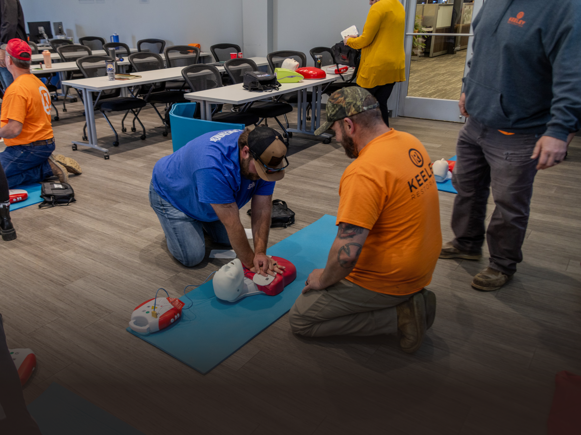 A group of men are practicing a heart massage on a mannequin.