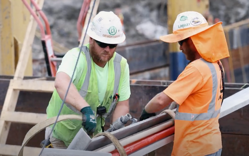 Two construction workers are working on a construction site.