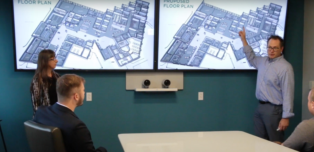A man is giving a presentation to a group of people in a conference room.