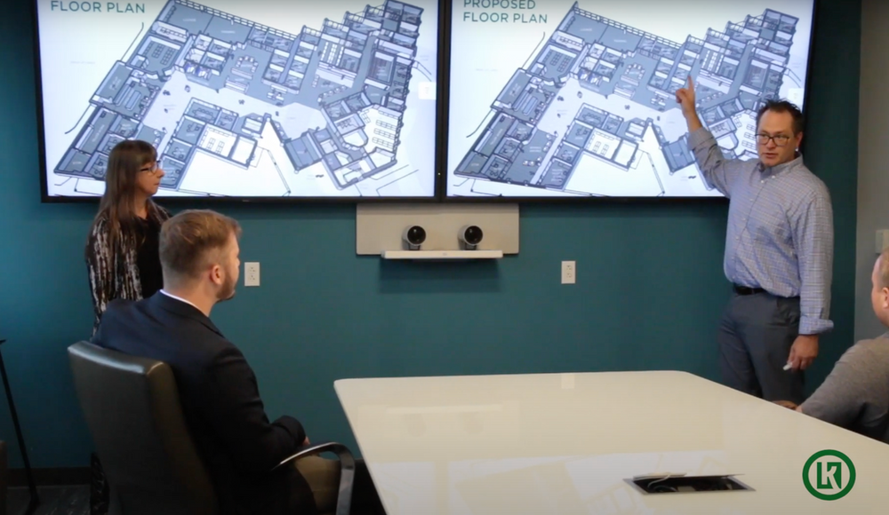 A man is giving a presentation to a group of people in a conference room.