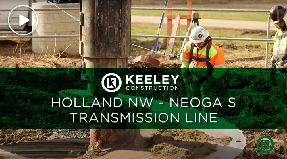 A group of construction workers are working on a transmission line.