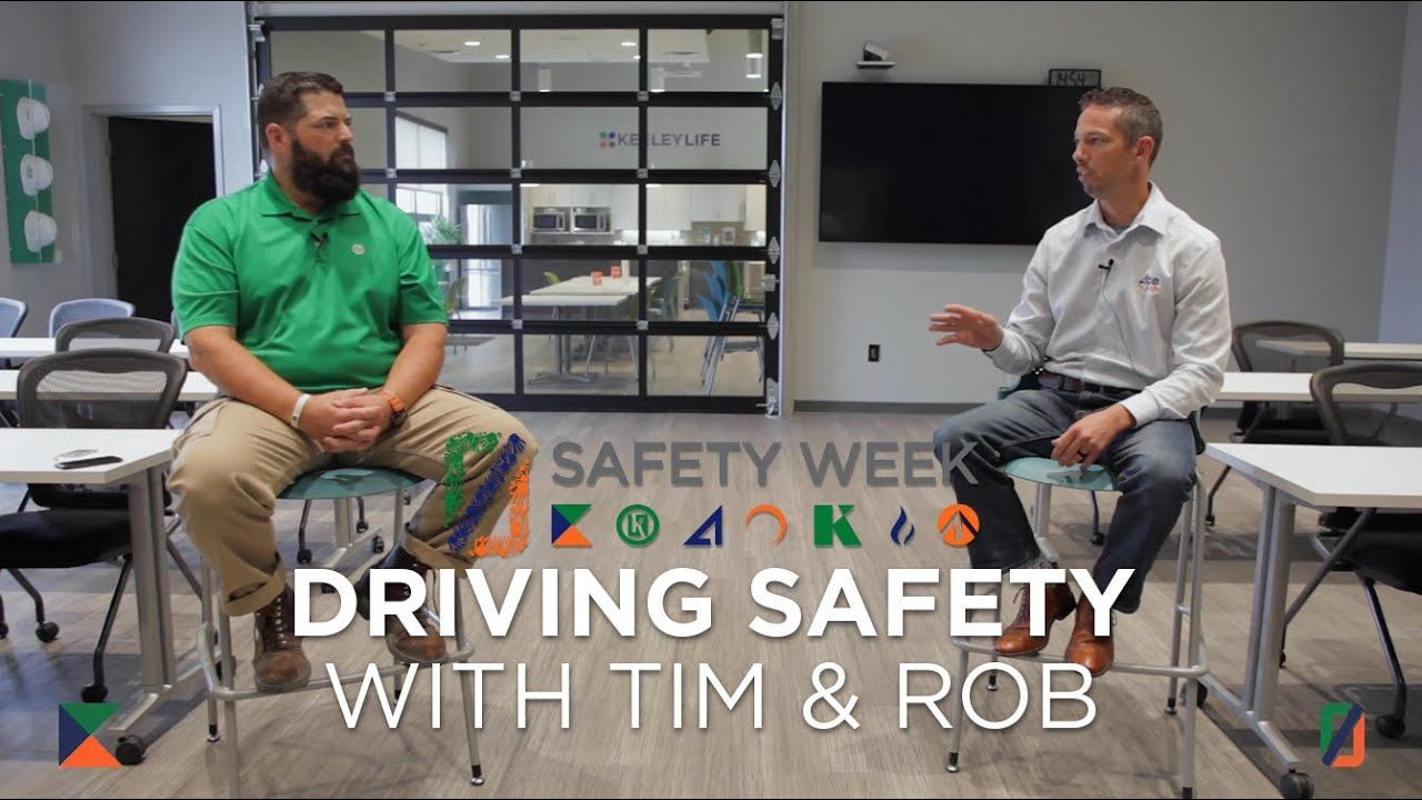 Two men are sitting at tables talking about driving safety