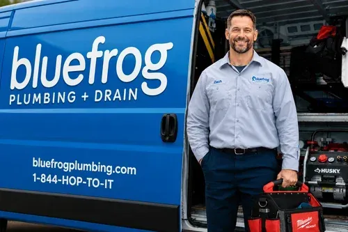 Bluefrog Plumbing & Drain van with smiling technician holding a tool bag