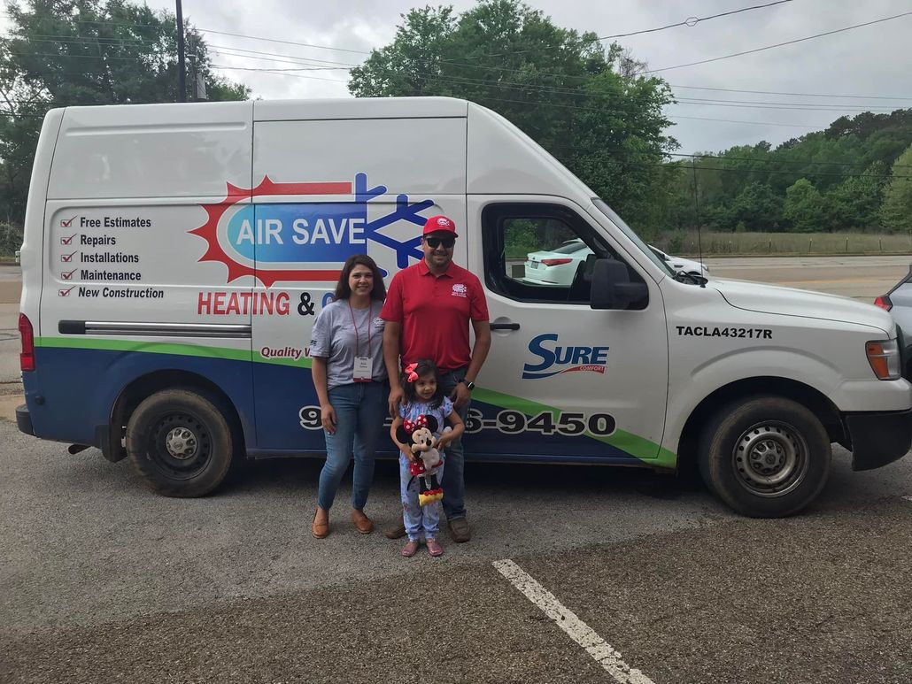 A man , woman and child are standing in front of an air save van.