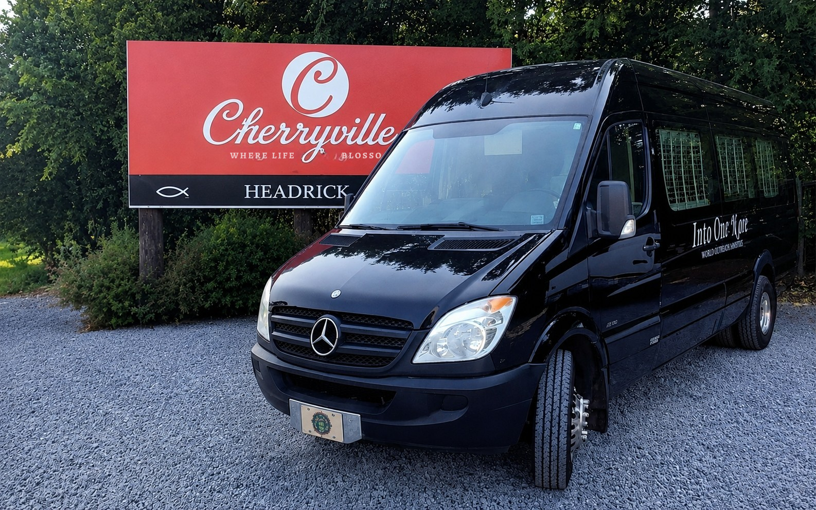 Into Our Kare mobile funeral service vehicle parked beside the Cherryville welcome sign in Cherryville, North Carolina