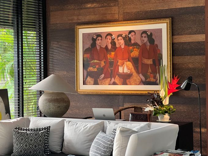 Modern living room with a large framed painting above a sofa and a lamp by the window