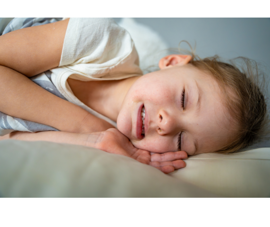 Child sleeping peacefully while parents monitor nighttime teeth grinding concerns