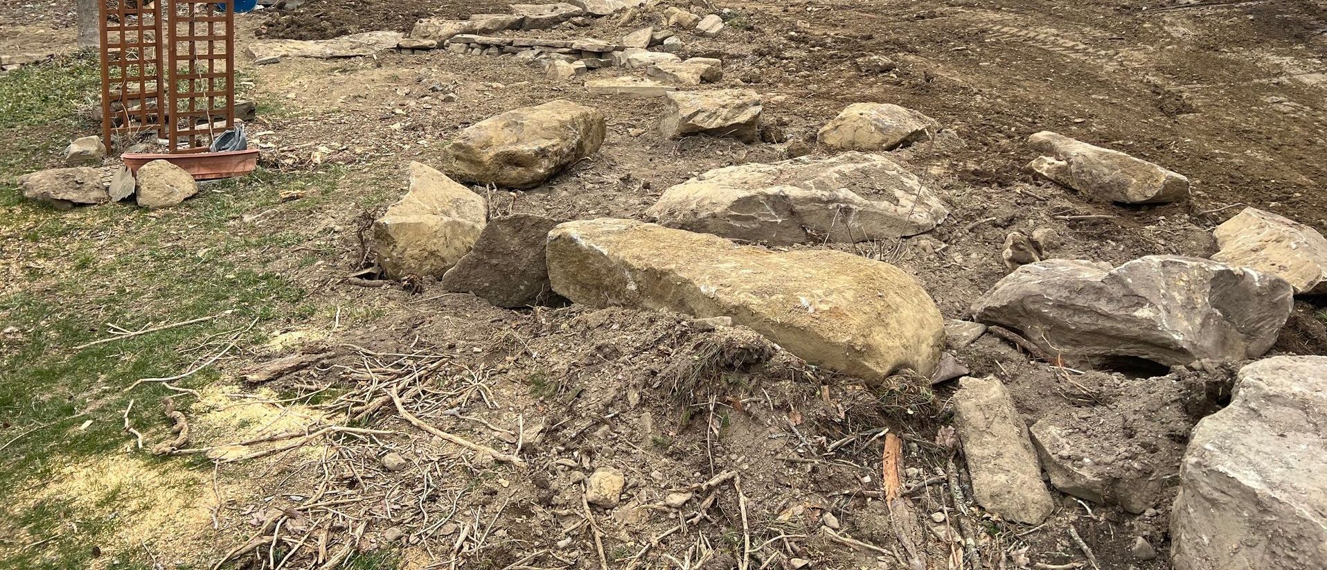 A pile of rocks sitting on top of a dirt field.