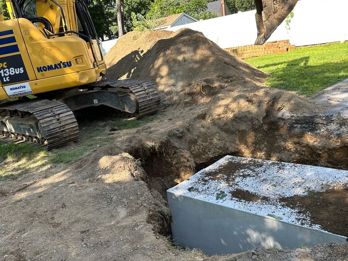 A yellow excavator is digging a hole in the ground next to a pile of dirt.