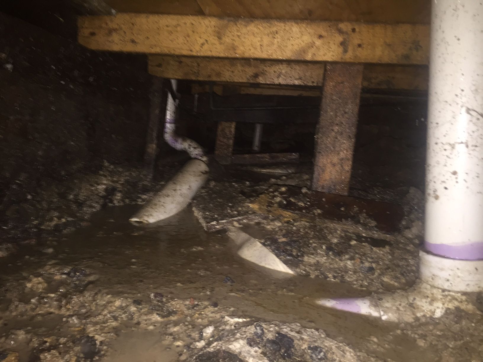 A dirty basement with a lot of water coming out of it.