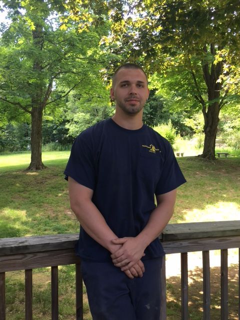 A man in a blue shirt is sitting on a railing