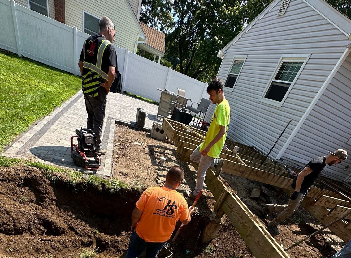 A group of construction workers are working on a project in front of a house.