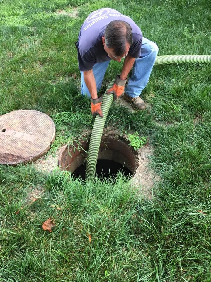 A man is pumping water into a septic tank.