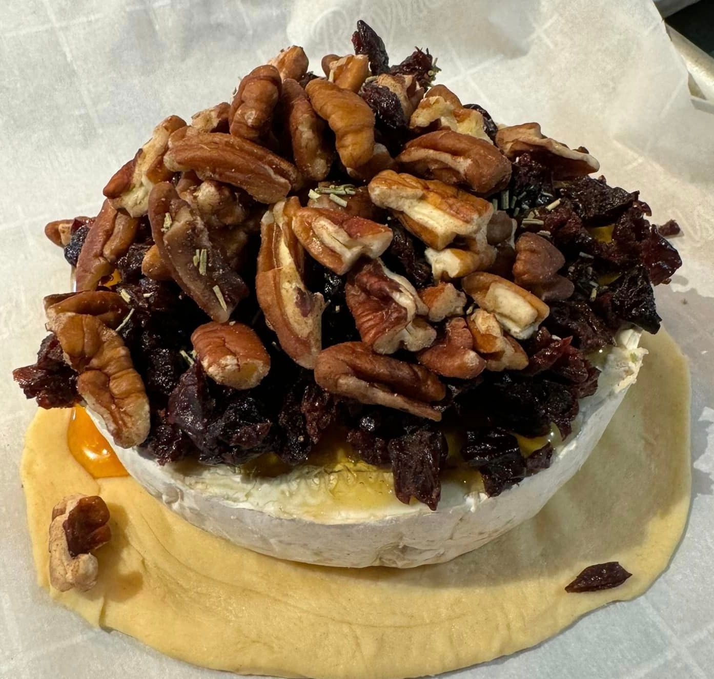 A bowl of food with pecans and raisins on top