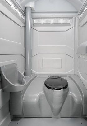 The inside of a portable toilet with a toilet and urinal.