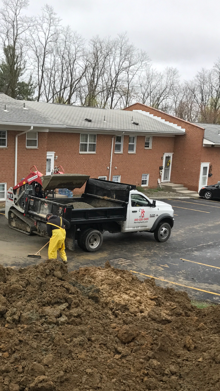 A dump truck is parked in front of a brick building.