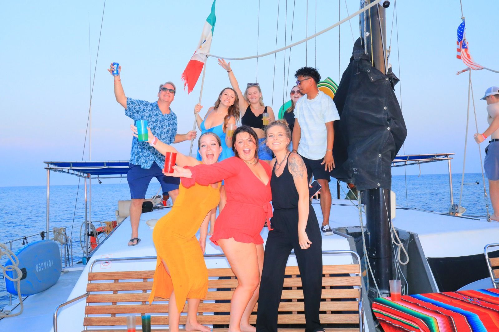 A group of people are posing for a picture on a boat in the ocean.