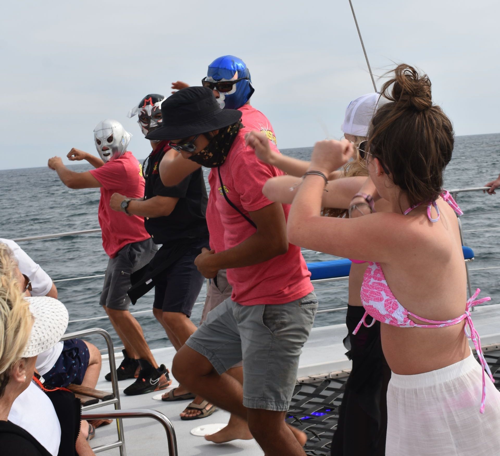 A group of people wearing masks are dancing on a boat