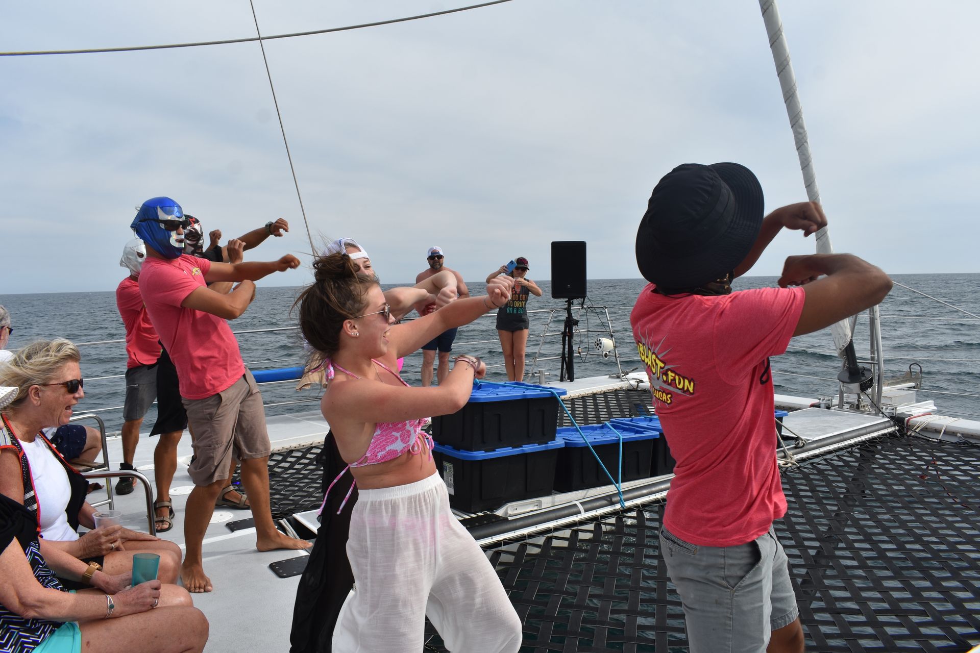 A group of people are dancing on a boat in the ocean.