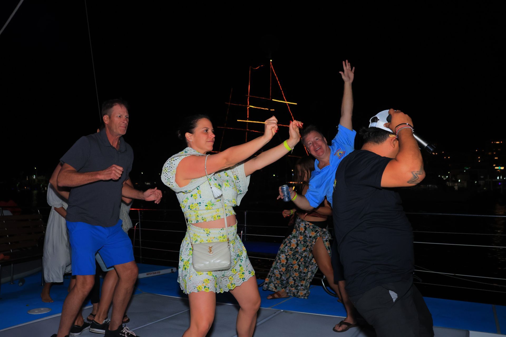 A group of people are dancing on a boat at night.