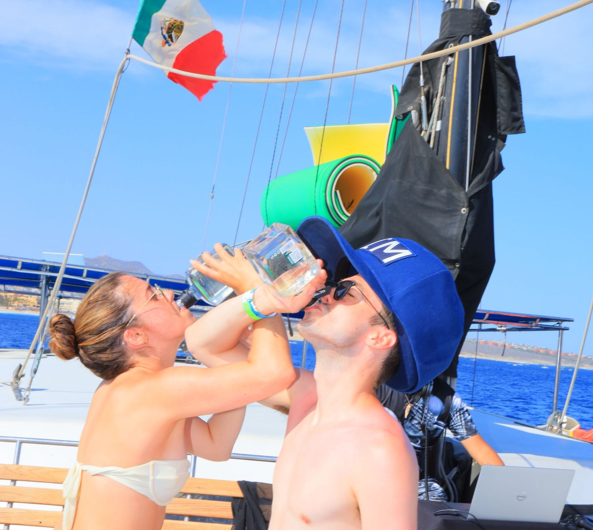 A man wearing a hat that says ny is drinking from a bottle