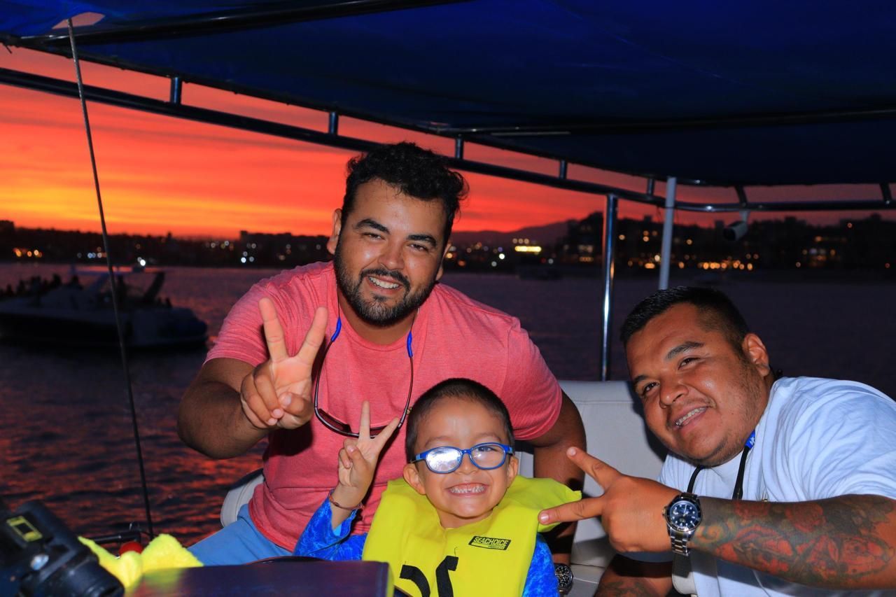 Two men and a child are posing for a picture on a boat.