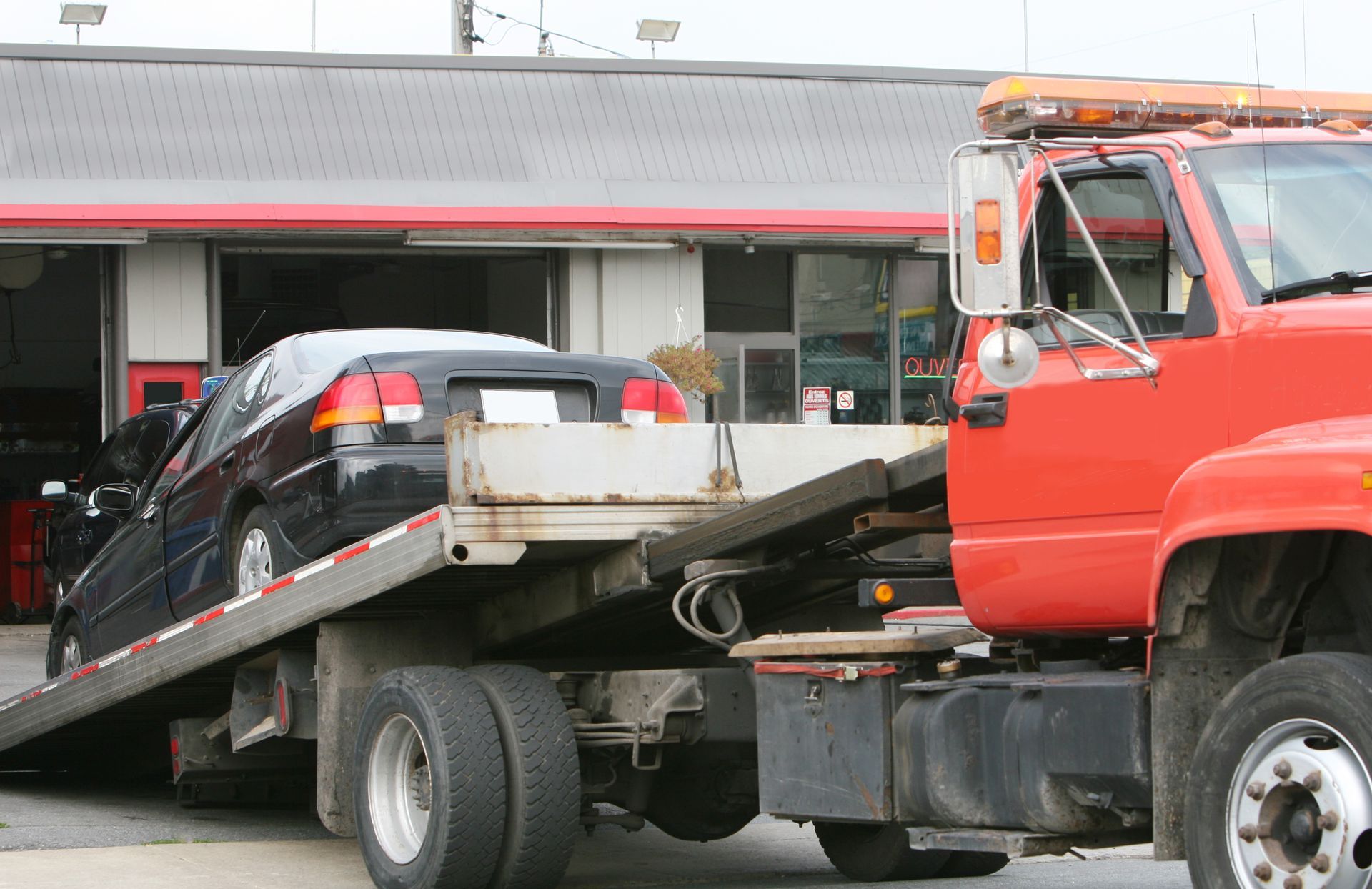 Tow truck bringing a car at the car repair shop. 
