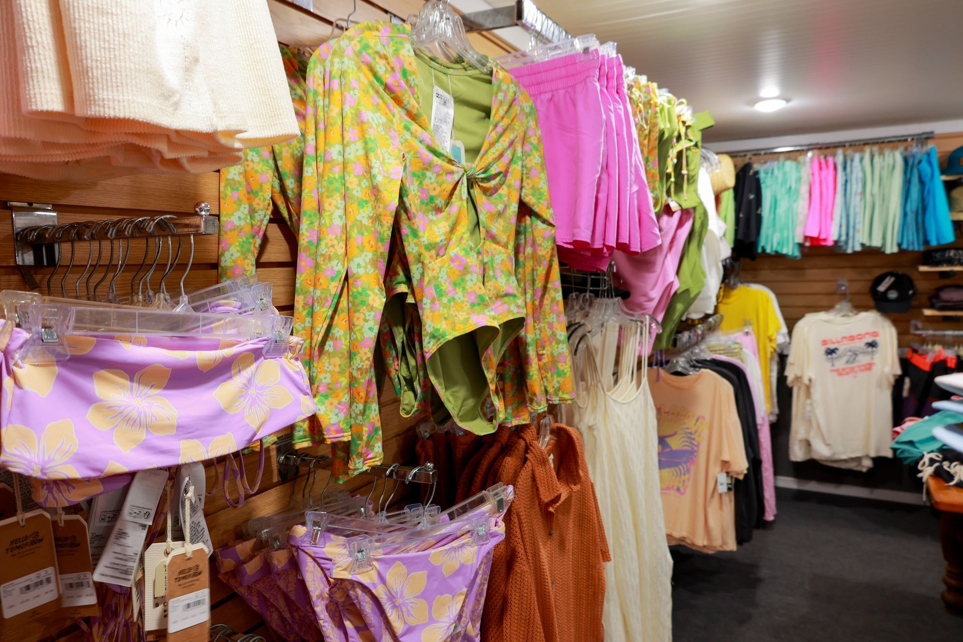 A bunch of clothes are hanging on a wall in a store