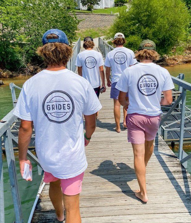 A group of young men are walking across a wooden bridge.
