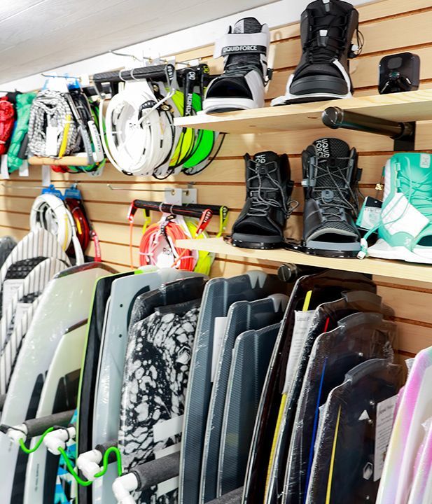 A bunch of surfboards are hanging on a wall in a store