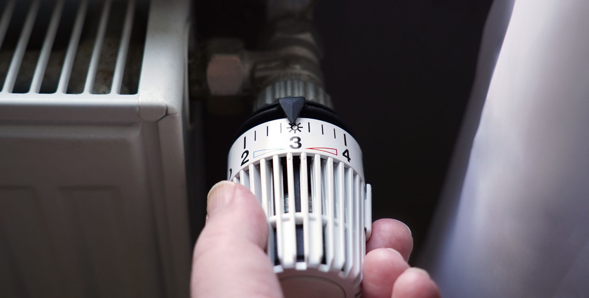 Turning down thermostat on radiator to save energy.