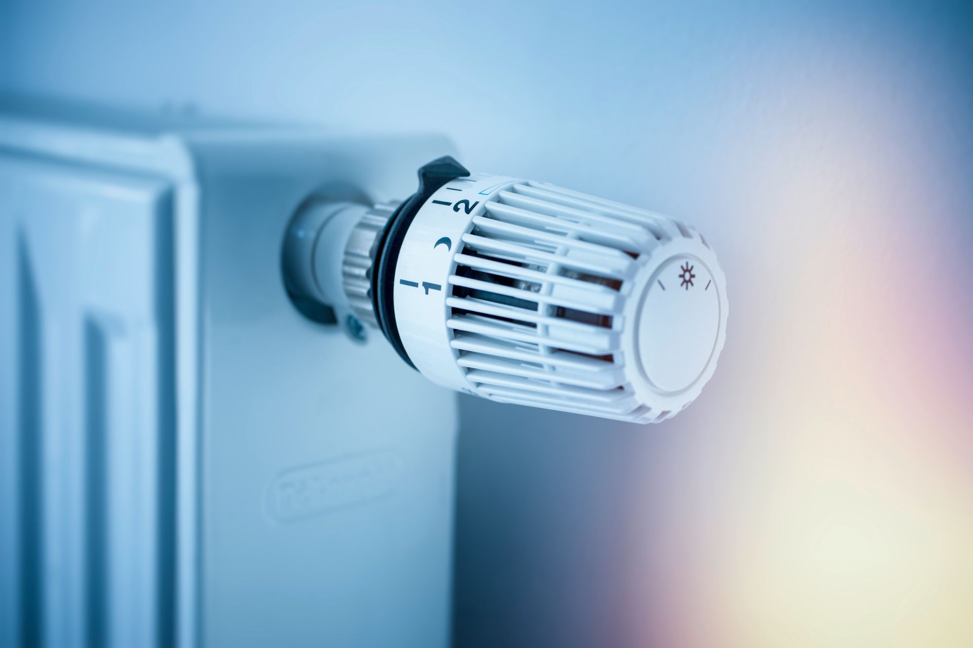 White panel radiator with a modern thermostat on the wall in an apartment