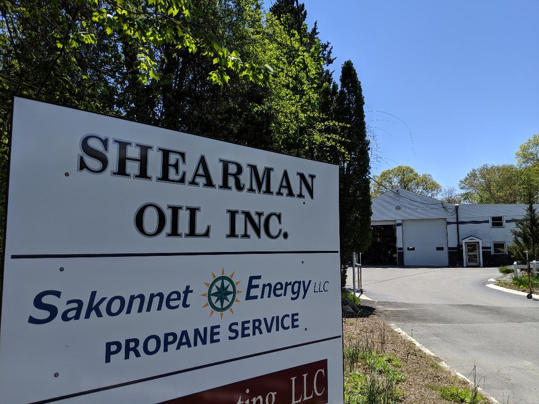 A sign for shearsman oil inc. is in front of a building