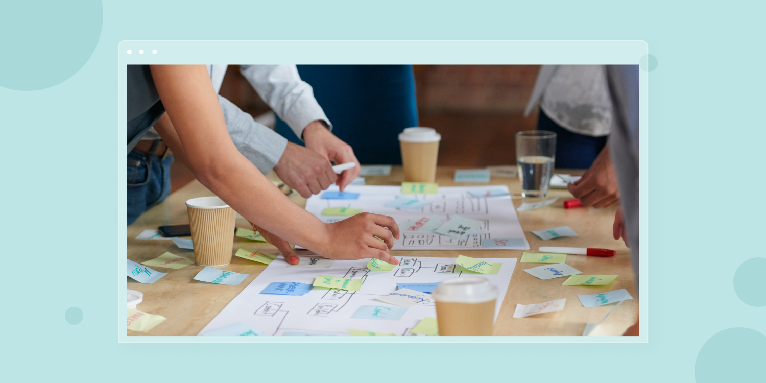 A group of people are looking at a piece of paper with sticky notes on it
