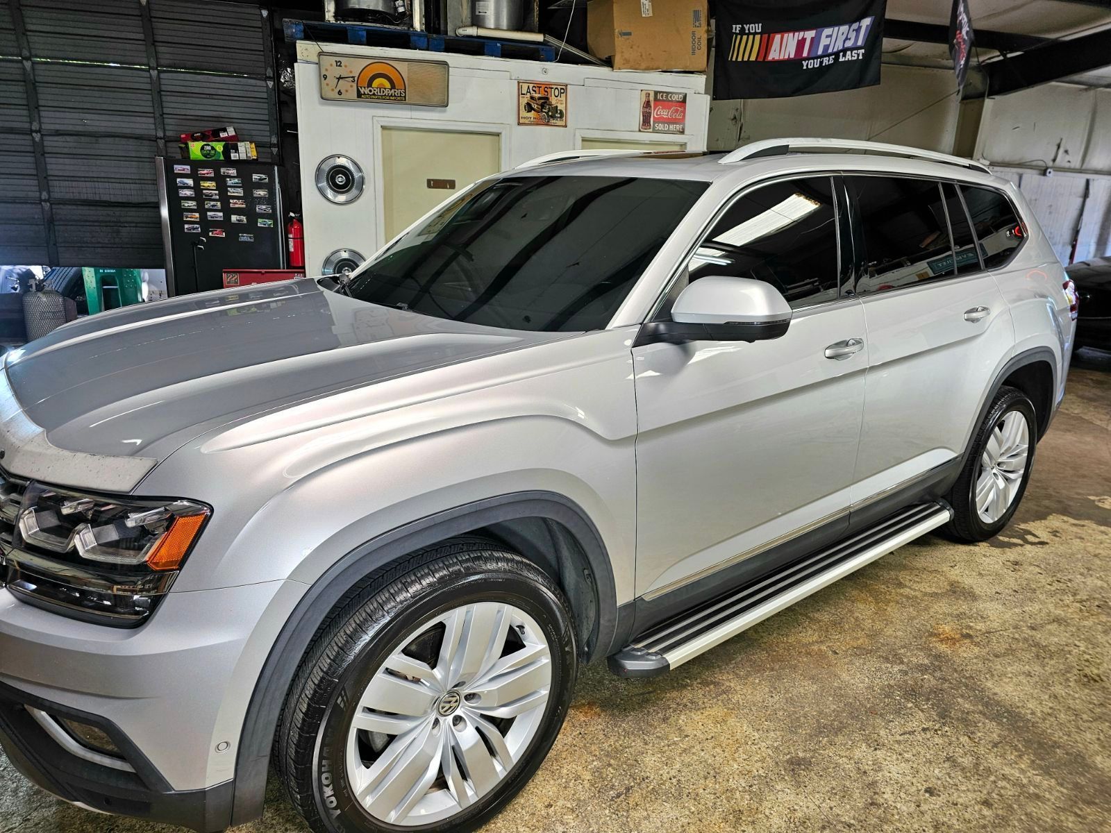 Silver SUV parked inside a garage; side steps and tinted windows visible.