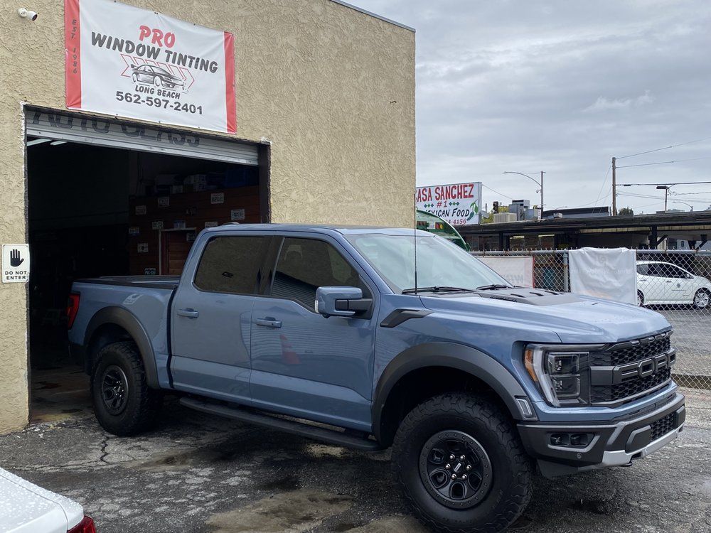 Blue pickup truck outside a business called Pro Window Tinting.