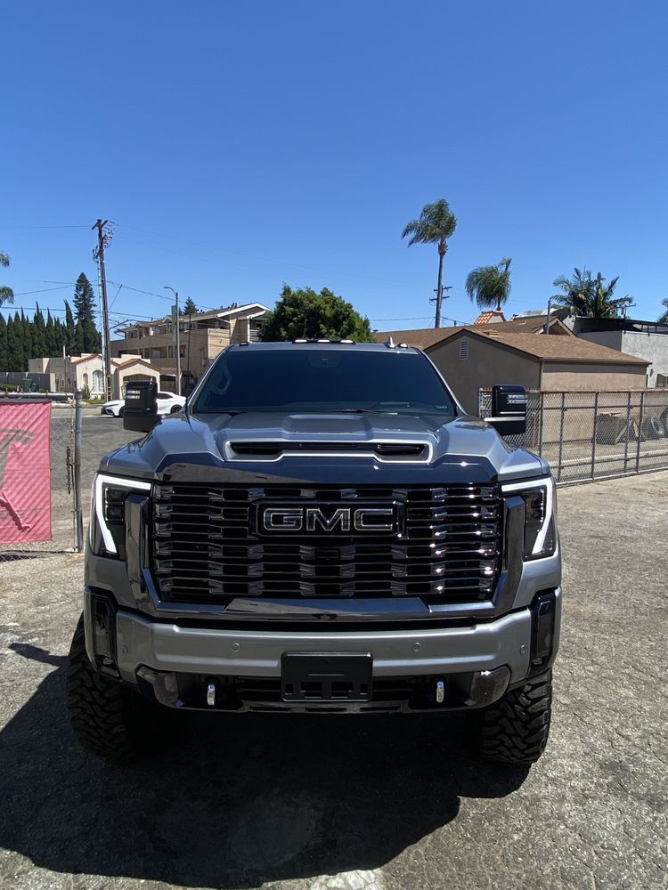 Gray GMC Sierra pickup truck parked on concrete, sunny day.