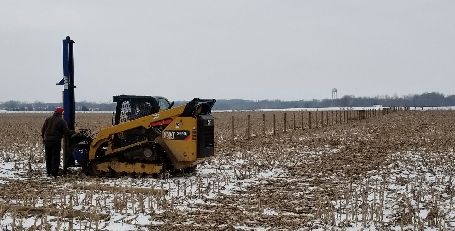 Man Standing Beside A Snow-Covered Tractor - Columbus, IN - Indiana Agricultural Fencing