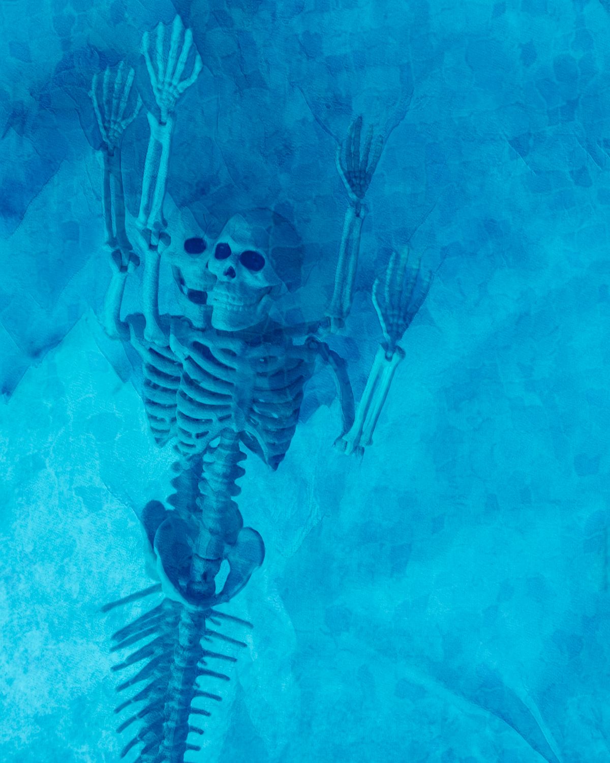 A skeleton is floating on top of a fish skeleton in the water.