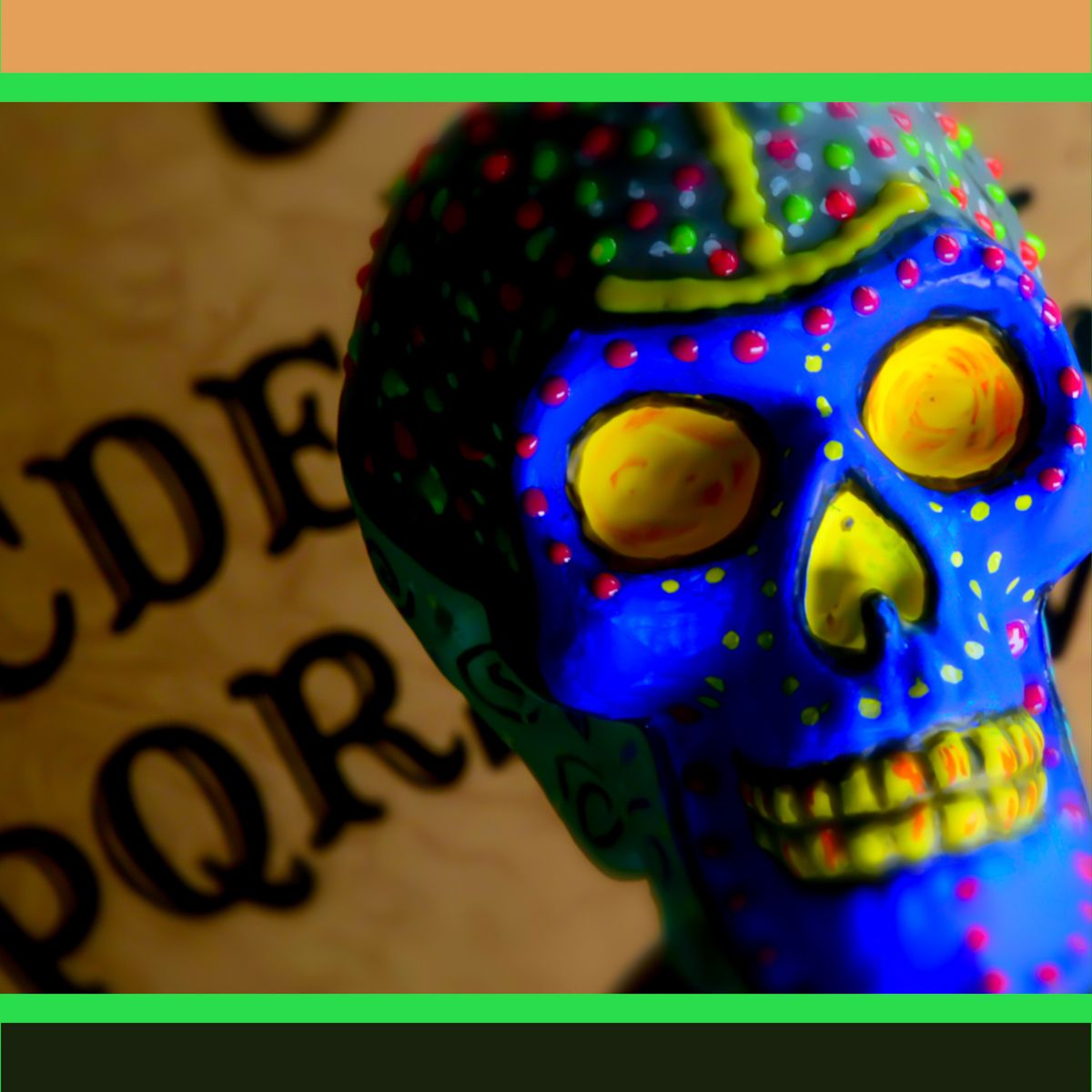 A blue skull with yellow eyes sits in front of the alphabet