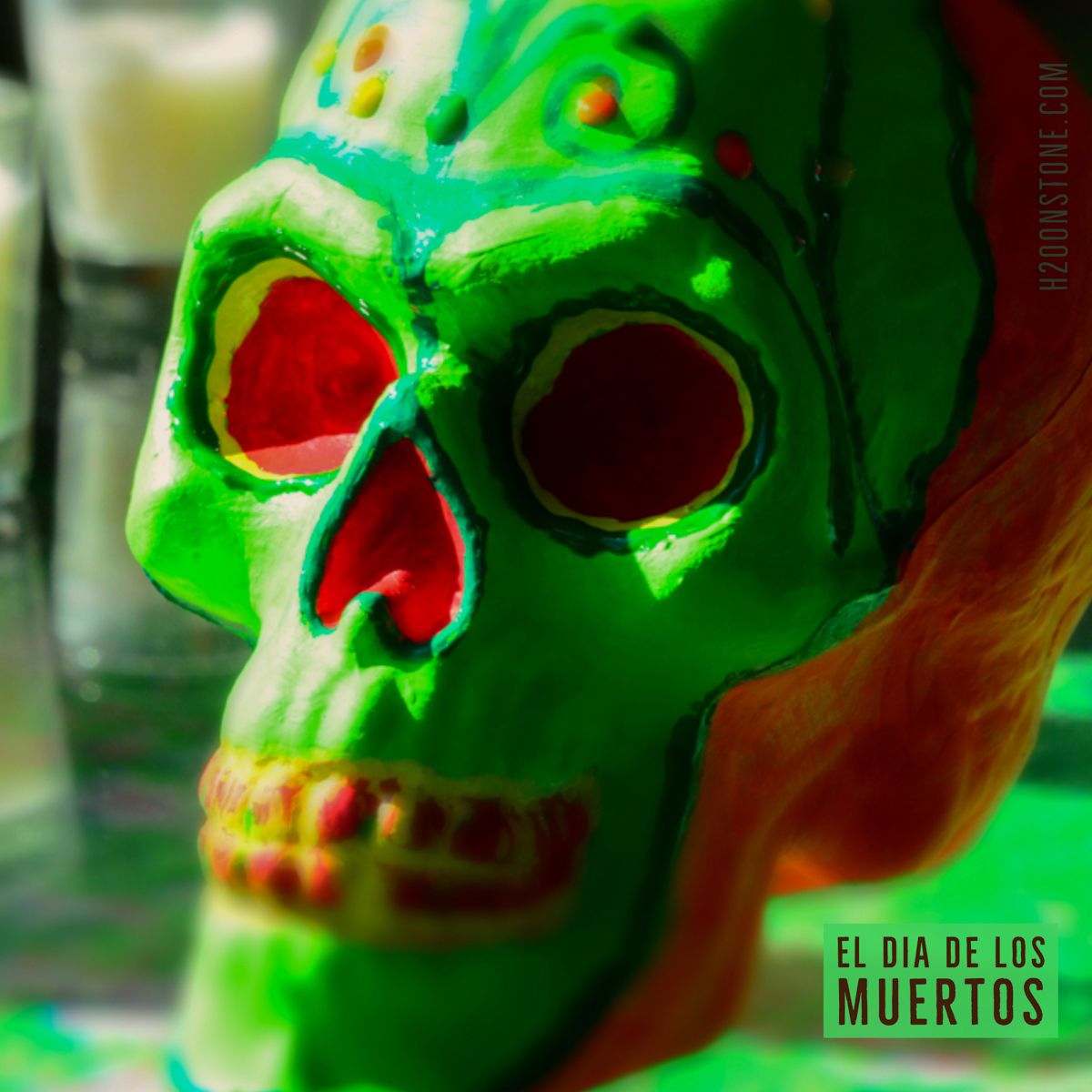 A green skull with the words el dia de los muertos below it
