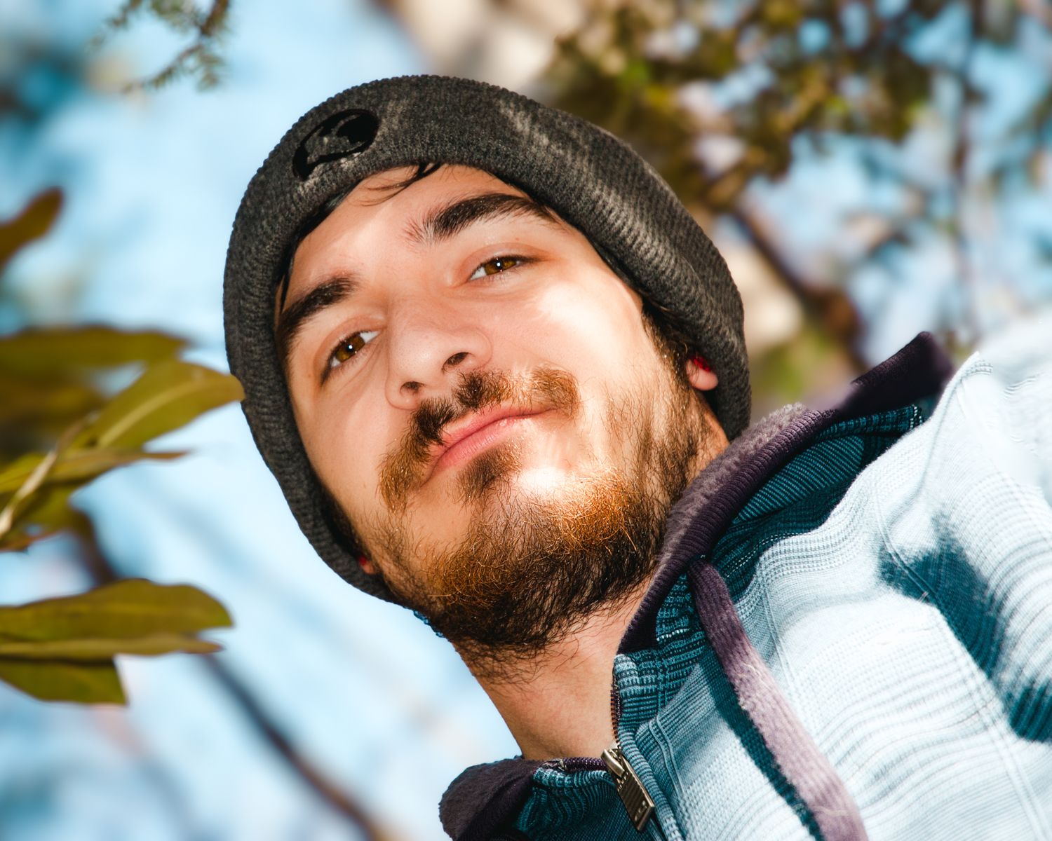 A man with a beard wearing a beanie and a jacket