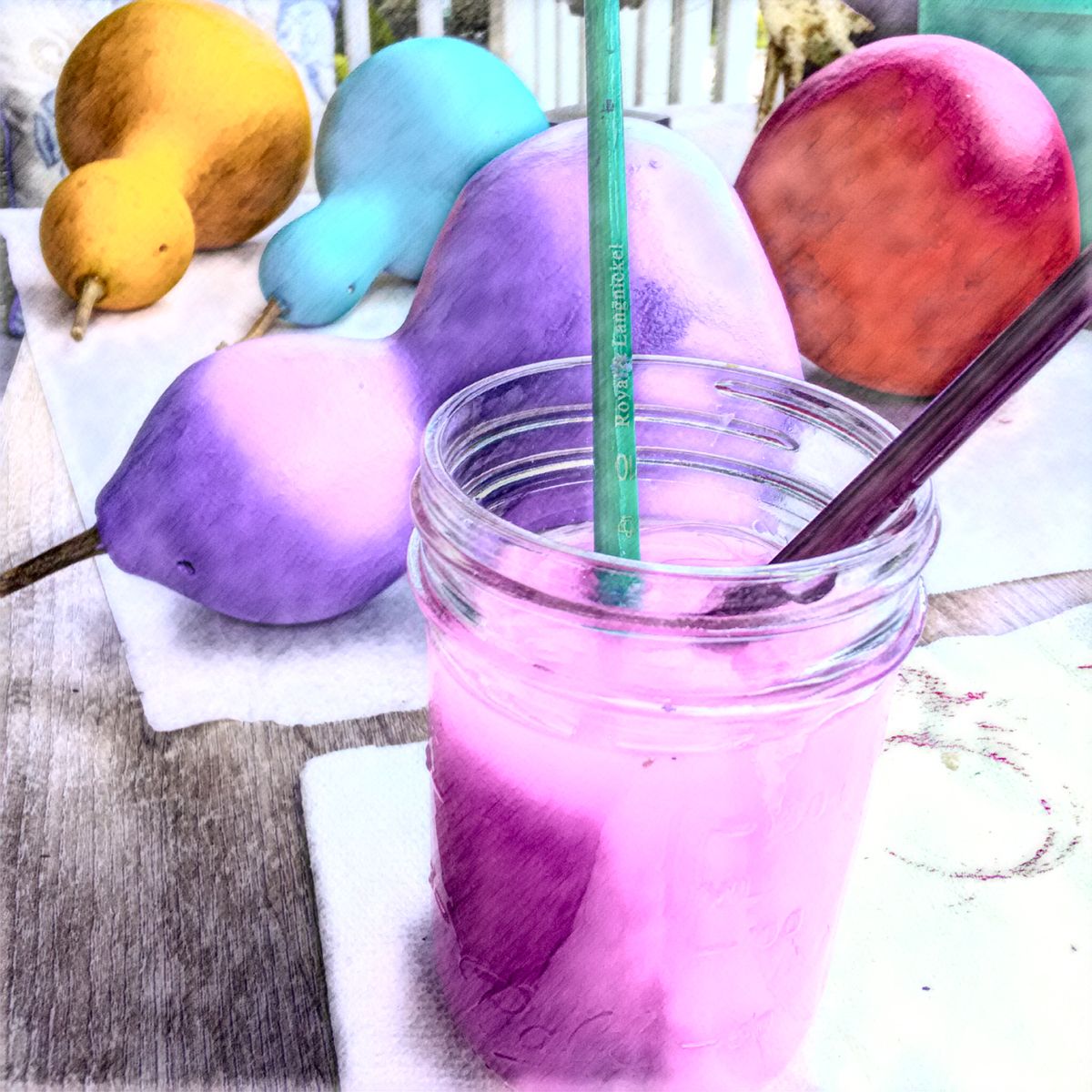 A mason jar filled with pink liquid next to a pencil