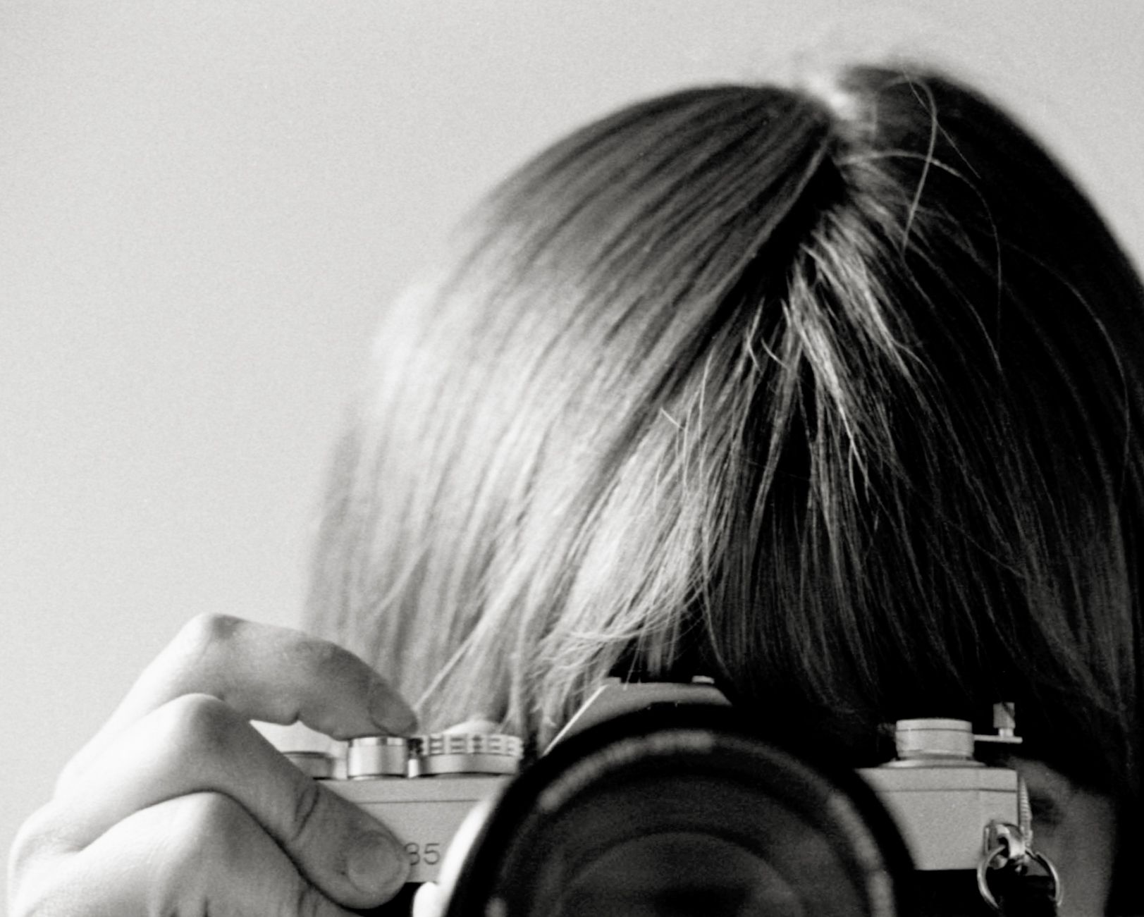 A black and white photo of a woman taking a picture