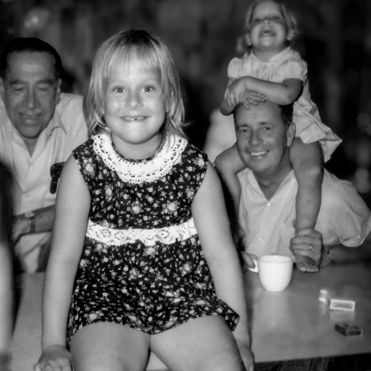A little girl is sitting on a man 's shoulders